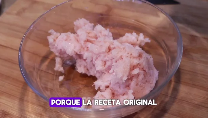 Sazonar el pollo picado con sal, pimienta y especias al gusto. Mezclar bien. (Este paso es añadido, la receta original no lo incluye).