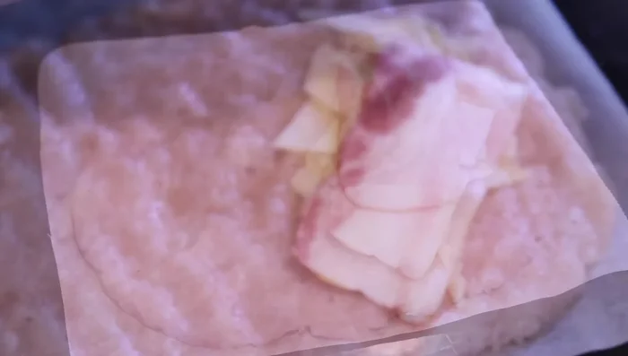 Doblar el círculo de pollo por la mitad para formar una media luna, sellando los bordes. Ajustar la forma con el papel de horno, para facilitar la cocción.