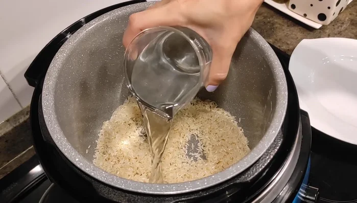 Agrega agua y ajusta la sal si es necesario. Remueve para que el arroz se reparta bien.