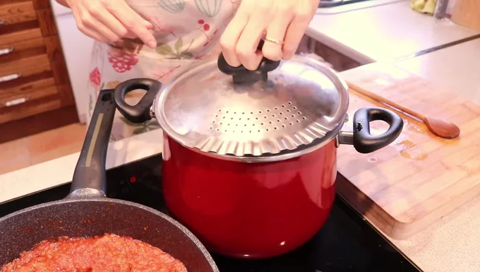 Escurre la pasta (sin dejarla completamente seca) y añádela al sofrito con la salsa de tomate. Mezcla bien.