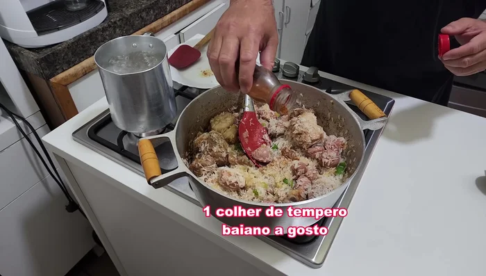 Lavar el arroz (opcional) (424.56) y añadirlo a la sartén. Agregar sal, condimento bahiano y orégano/cebollino/cilantro a gusto (442.639).