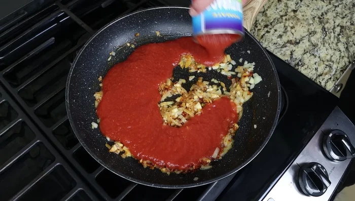 Agregar la salsa de tomate, sal y pimienta. Mezclar bien y cocinar a fuego lento durante 3 minutos hasta que espese ligeramente.