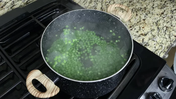 Añadir los guisantes congelados y cocinar de 2 a 3 minutos hasta que estén tiernos. Escurrir y enjuagar con agua fría. (66.799)