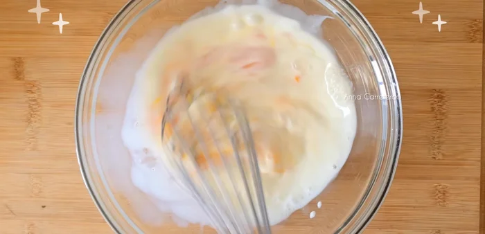 En un bol aparte, bate 200 ml de leche, un huevo, dos yemas, una cucharadita de vainilla y tres cucharadas y media de maicena hasta que no queden grumos.