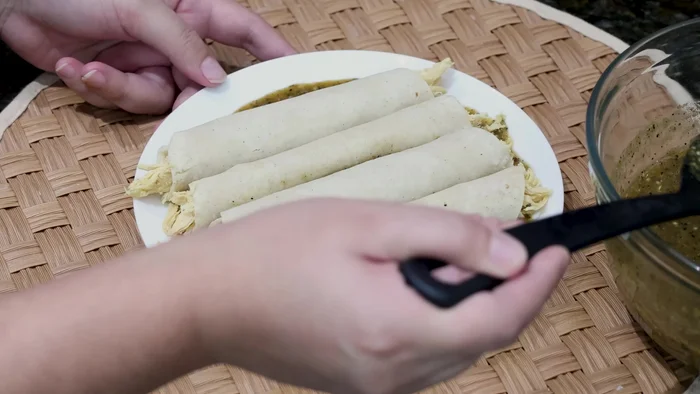 Colocar las enchiladas en un plato, cubrir con salsa verde y queso manchego (o el queso de tu preferencia).