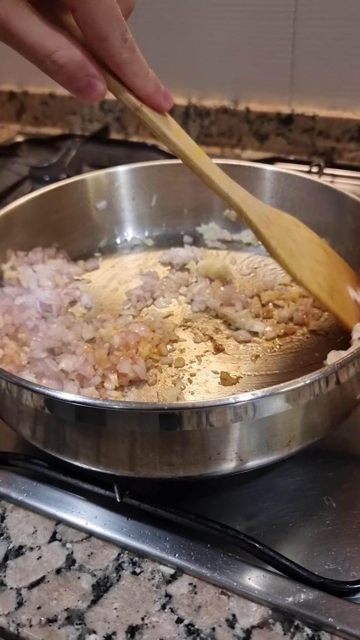 Sofreír cebolla y ajo (100.72). Agregar sal, pimienta, comino, cúrcuma y mezclar (109.28).