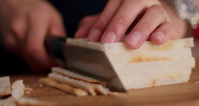 Cortar los bordes del pan de sándwich (203.799). Humedecer ligeramente el pan con agua (214.36) y presionar suavemente para eliminar el exceso de agua (220.72).