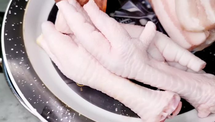 Añadir el chorizo, panceta, patas de pollo (opcional), zanahoria, laurel, cebolla, ajo y clavos de olor.