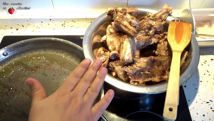Reservar la carne. En la misma olla, sofreír ajos picados, romero y tomillo.