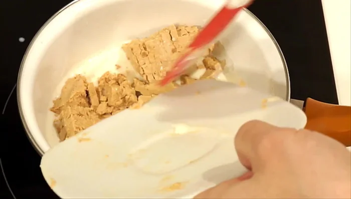 Añadir el turrón picado al cazo. Remover a fuego bajo hasta que se forme una crema uniforme.