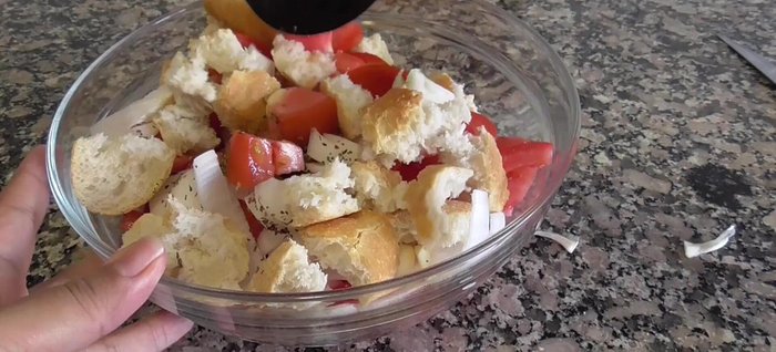 Mezclar todo para que el pan se humedezca con el jugo de los tomates.