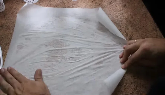 Colocar papel de horno sobre el molde humedeciéndolo ligeramente para facilitar su manejo.