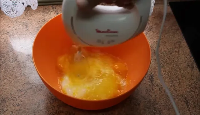 Mezclar en un bol el azúcar y los huevos con la batidora hasta obtener una masa espesa.