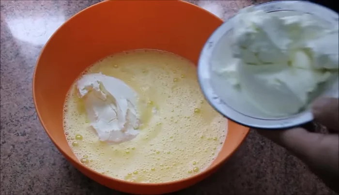 Añadir las 2 tarrinas de queso crema y remover con varillas hasta integrar.