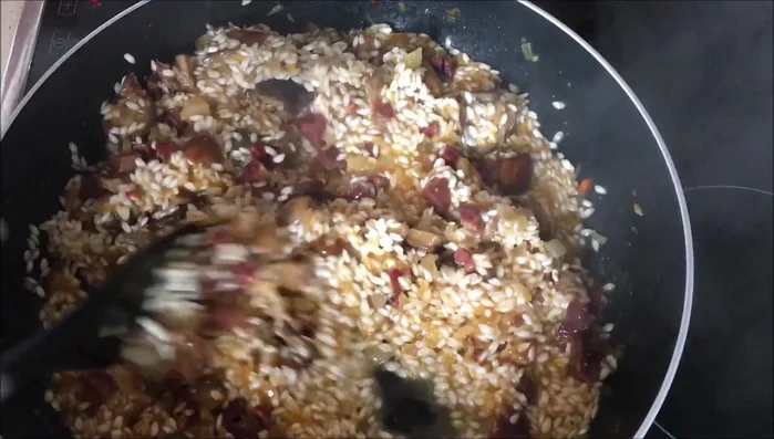 Añadir más caldo en dos tandas, removiendo hasta que el arroz esté hecho al dente.