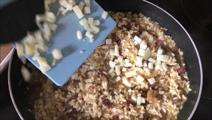 Apagar el fuego, añadir el queso manchego cortado en tacos pequeños y remover hasta que se derrita.