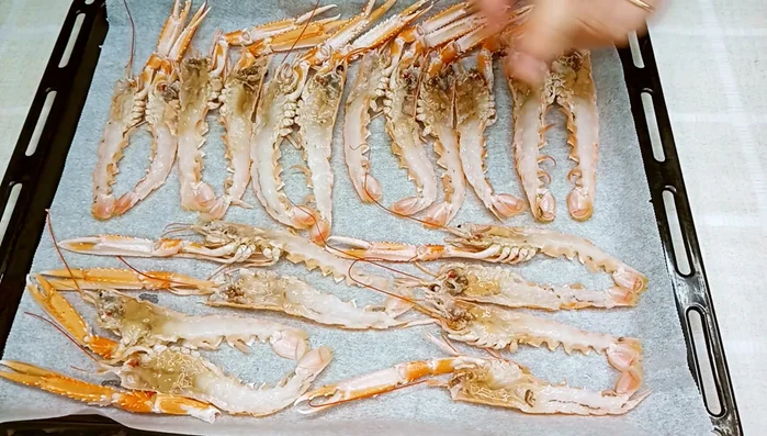 Colocar las cigalas en una bandeja de horno con papel.