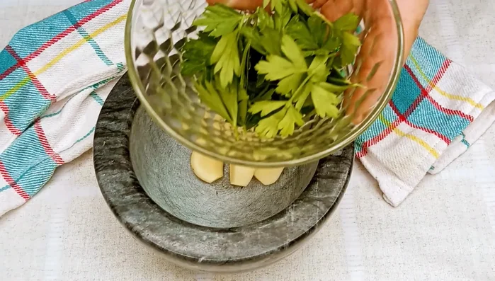 En un mortero, machacar 4 dientes de ajo, perejil fresco, y sal hasta formar una pasta.