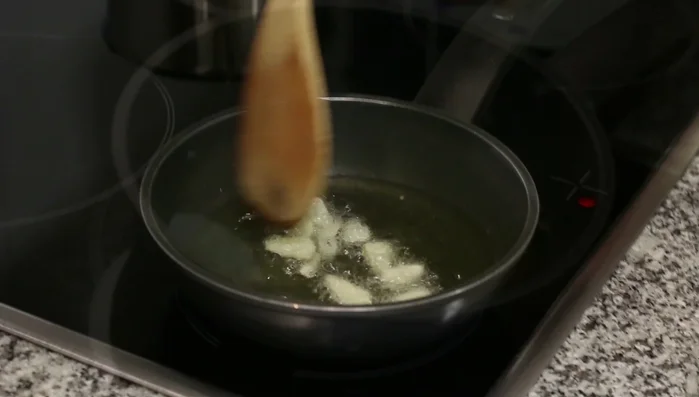 Agregar pimentón dulce al ajo sofrito, fuera del fuego, y remover rápidamente para evitar que se queme. Dejar reposar para que las impurezas se depositen en el fondo.