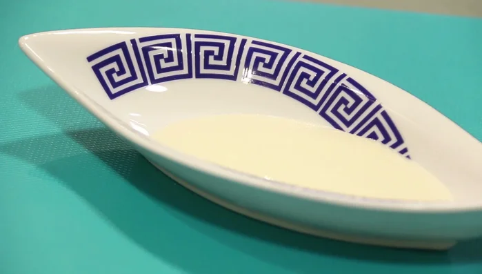 Servir el pulpo frito sobre la crema de queso San Simón da Costa, decorando con huevas de erizo.