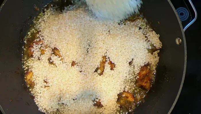 Agregar el arroz bomba, remover para que absorba la grasa (196.4).