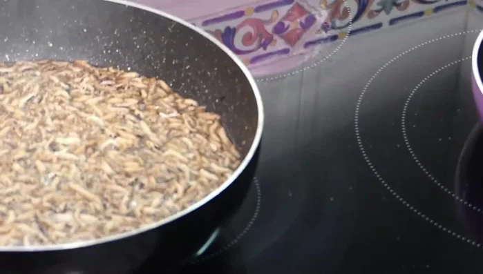 Escurrir el arroz y ponerlo sobre papel absorbente para eliminar el exceso de humedad. Salar y mezclar con las manos.