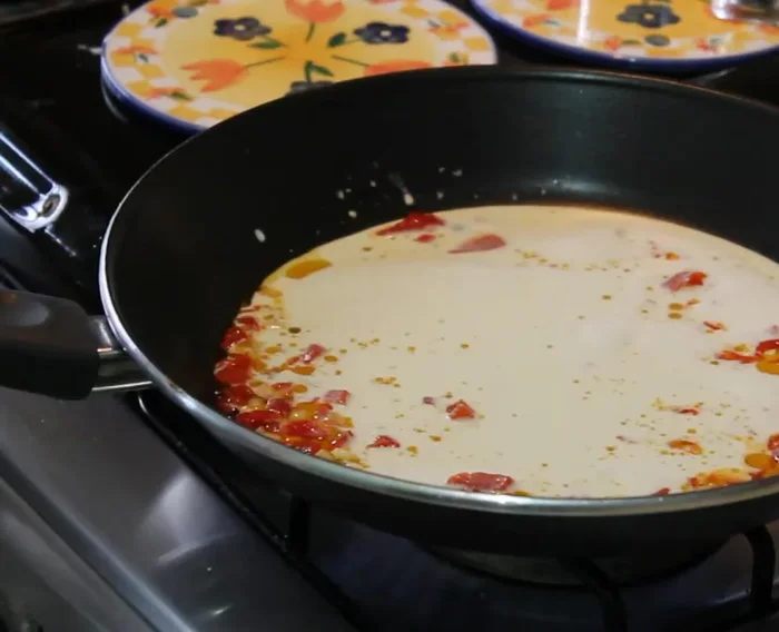 Agregar la crema de leche, salpimentar y dejar hervir (40.28).