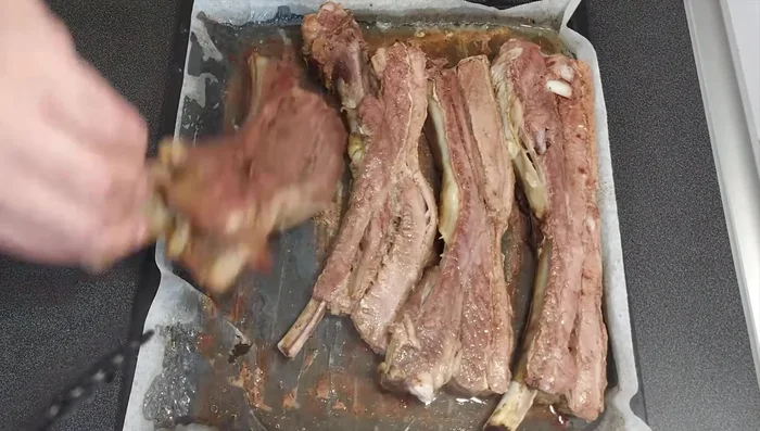 Dar la vuelta a las costillas y untar la parte inferior con el majado restante.