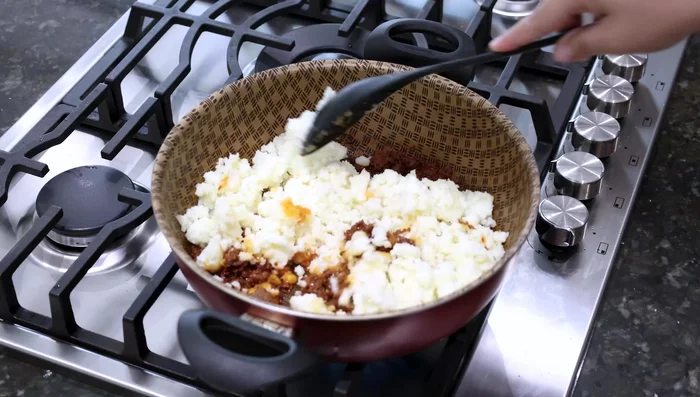 Agregar el puré de papa al chorizo y mezclar bien.