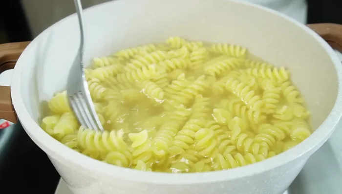 Cocer la pasta al dente. Agregar sal al gusto y cocinar un minuto menos del tiempo indicado en el paquete. [87.68]