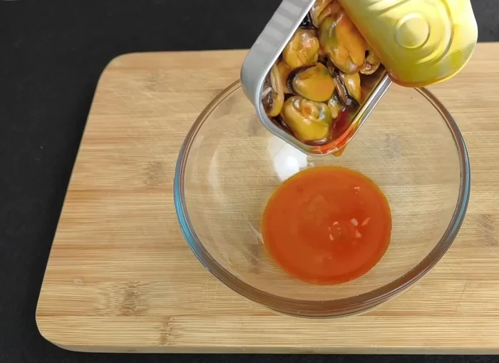 Preparar la vinagreta: Utilizar el escabeche de los mejillones, las yemas de huevo, aceite de oliva, pimentón dulce y mezclar. (92.439)