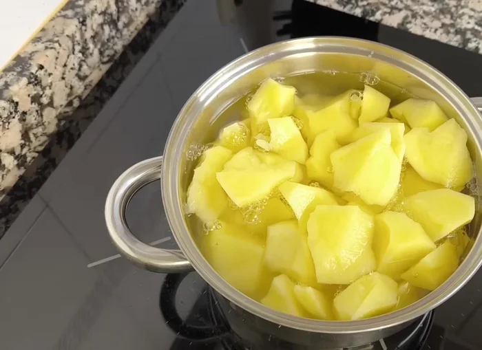 Cocer las patatas en trocitos pequeños con un poco de sal a fuego máximo hasta que hierva. Luego, bajar el fuego al mínimo, tapar y esperar hasta que estén tiernas. (24.359)