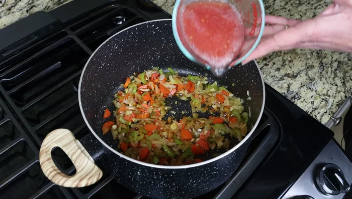 Agregar la salsa de tomate, mezclar y cocinar a fuego lento durante unos minutos.