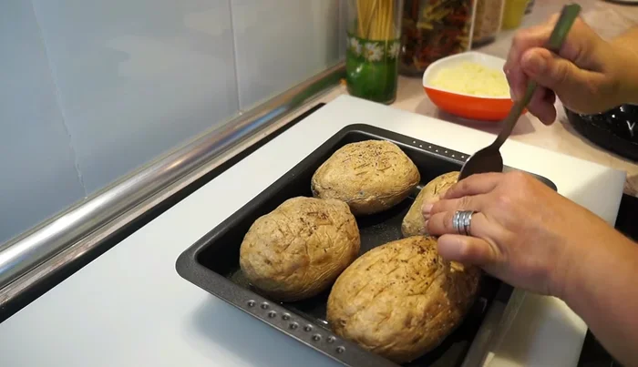 Una vez las patatas estén tiernas, abrir un hueco en el centro de cada una con una cuchara.