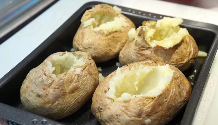 Rellenar las patatas con queso rallado.