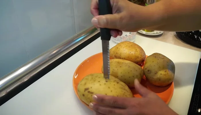 Colocar las patatas en una bandeja de horno, añadir aceite de oliva y hornear a 200°C (calor arriba y abajo) durante 50 minutos a 1 hora (dependiendo del tamaño).