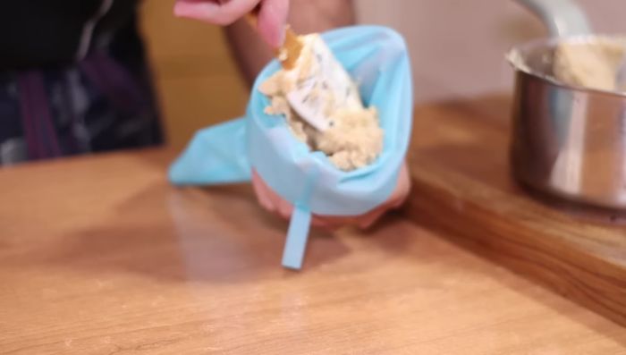 Verter la masa en una manga pastelera (o churrera) con boquilla rizada.