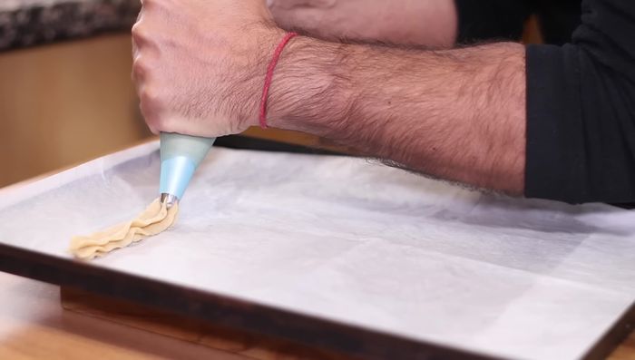 Formar los churros sobre una placa de horno cubierta con papel de hornear.