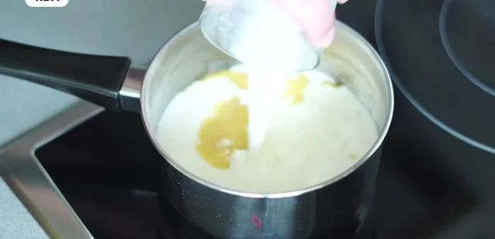 Agregar la leche gradualmente, sin dejar de remover, hasta que la salsa espese. Sazonar con sal y pimienta. Incorporar queso rallado.