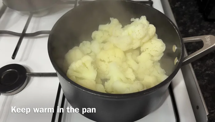 Escurre el agua y mantén la coliflor caliente.