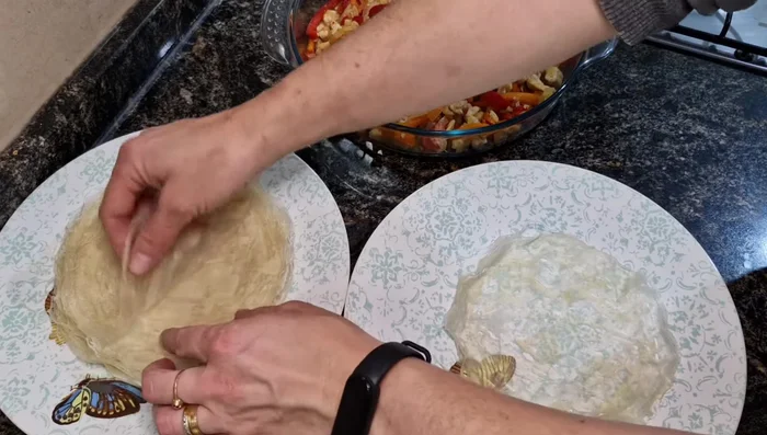 Armar los arrolladitos: colocar dos tapitas de masa, agregar relleno y un poco de queso, cerrar.