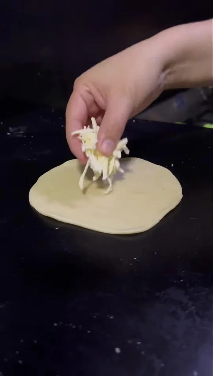 Colocar el queso rallado en el centro de cada tortilla y cerrarlas presionando los bordes. (106.88)