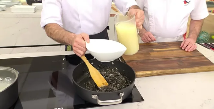 Añadir el caldo de ave poco a poco, cocinando durante 5 minutos a fuego alto, 5 minutos a fuego medio, 5 minutos a fuego bajo y 5 minutos de reposo.