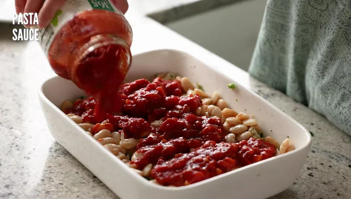 Hornear a 200°C (400°F) durante 20-25 minutos, hasta que la salsa esté burbujeante y el queso derretido. [147.8]