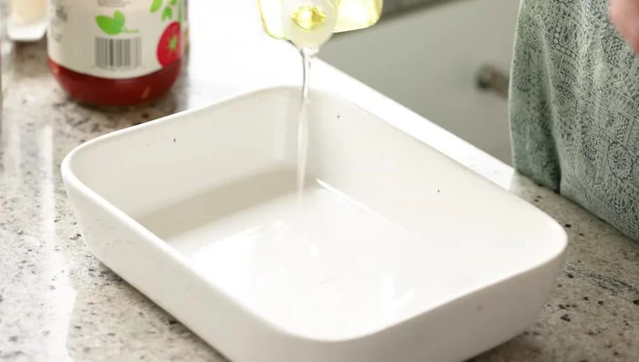 En una fuente para hornear, agregar un poco de aceite de oliva virgen extra (opcional). Desmenuzar el tofu y colocarlo en la fuente. [83.64]