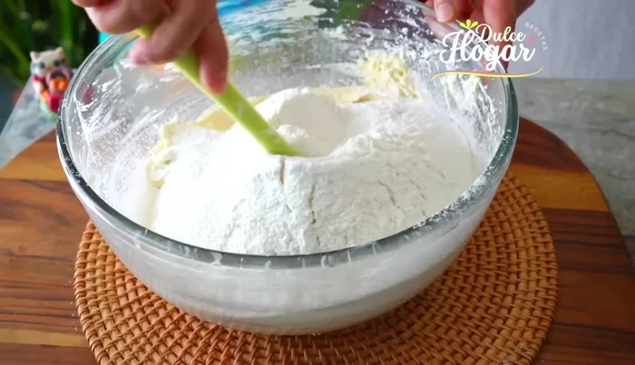 Agregar la mitad de los ingredientes secos a la mezcla de mantequilla, mezclar ligeramente. Agregar la mitad de la leche cortada y mezclar bien.