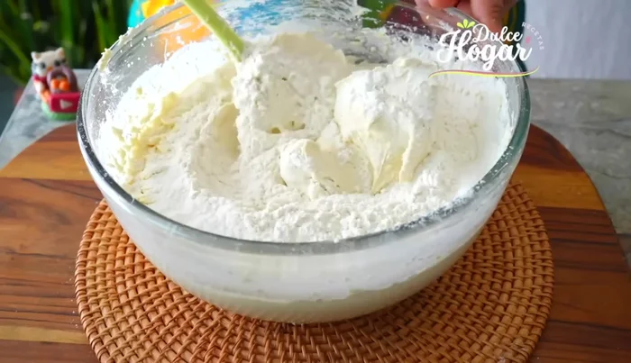 Agregar la otra mitad de los ingredientes secos y el resto de la leche cortada, mezclando solo hasta integrar.