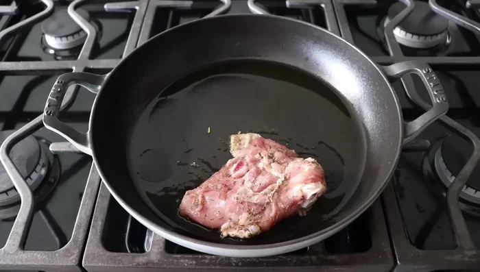 Doramos los muslos de pollo en una sartén a fuego medio-alto con aceite de oliva, con la piel hacia abajo, durante 5-6 minutos hasta obtener una costra dorada. Repetimos con el otro lado por 3-4 minutos.