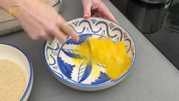 Al día siguiente, batir los huevos (2-3). Formar las croquetas con porciones de masa, pasarlas por huevo batido y luego por pan rallado.