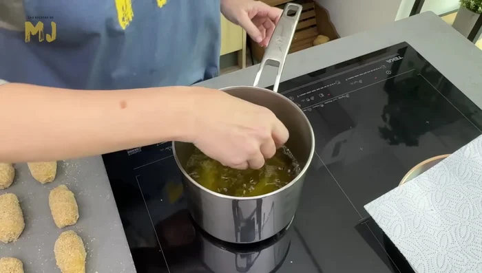 Freír las croquetas en aceite de oliva virgen extra caliente hasta que estén doradas. Retirar sobre papel absorbente.